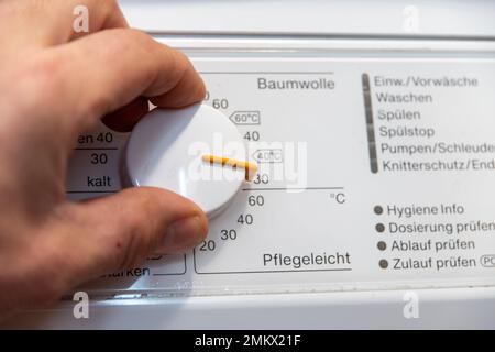 Hand on the temperature controller of a washing machine Stock Photo