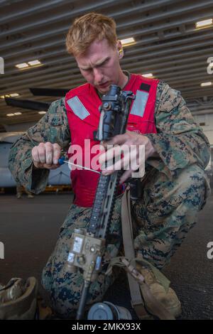 220913-N-VJ326-1163 PHILIPPINE SEA (Sep. 13, 2022) -- U.S. Marine Corps Lance Cpl. Matthew Huddleston, from Independence, Missouri, assigned to the 31st Marine Expeditionary Unit (MEU), reassembles an M16A3 rifle during a small arms qualification shoot aboard amphibious assault carrier USS Tripoli (LHA 7) Sept. 13, 2022. Tripoli is operating in the U.S. 7th Fleet area of operations to enhance interoperability with allies and partners and serve as a ready response force to defend peace and maintain stability in the Indo-Pacific region. Stock Photo