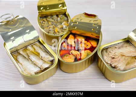 Assortment of cans of canned with different types of fish and seafood on rustic wooden table Stock Photo