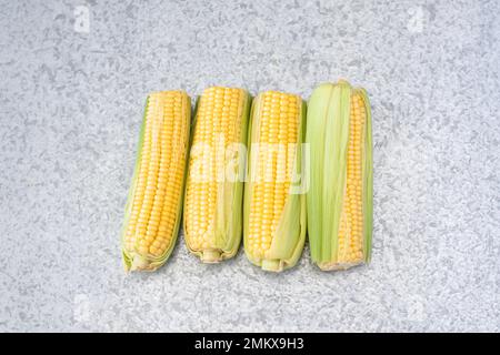 Four yellow corn cobs isolated, sweet corn. Stock Photo