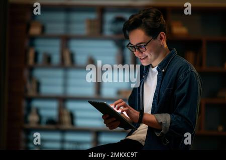 Smiling young man professional holding using digital tablet at office Stock Photo