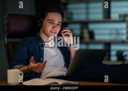 Cheerful guy project manager have online meeting late at night Stock Photo