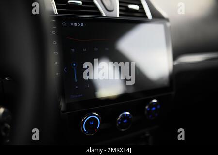 The process of choosing climate control in the car. Man regulating temperature on car air condition. Modern car interior Stock Photo