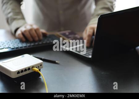 Modern dual band wireless router. Man working in the background. Fast wireless internet concept. Stock Photo