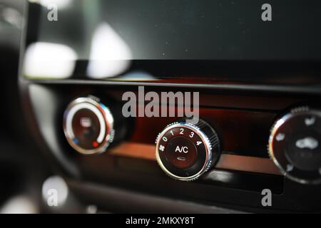 The process of choosing climate control in the car. Man regulating temperature on car air condition. Modern car interior Stock Photo