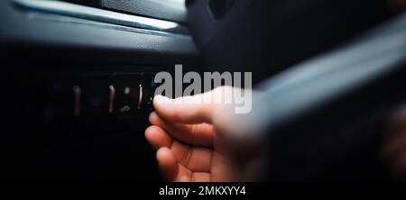 The process of choosing climate control in the car. Man regulating temperature on car air condition. Modern car interior Stock Photo