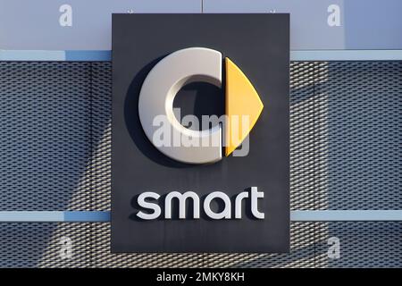 Italy, year 2023, Smart automotive car industry brand, illuminated sign on the building of an official dealer Stock Photo