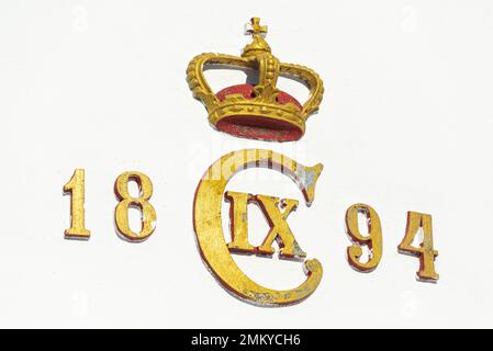 Year of construction, lettering and crown in gold and red on the white facade of Sletterhage lighthouse, Djursland, Jutland, Denmark Stock Photo