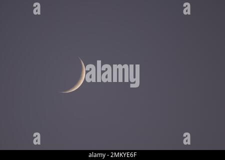 Waxing Crescent Moon in early evening sky in January 2022 Stock Photo