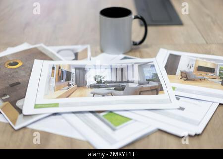 printed photo drawings of interior projects on the table and a mug of tea Stock Photo