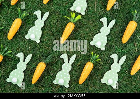 Easter pattern background made of decorative carrots and bunny rabbits on natural organic texture. Minimal festive spring concept. Stock Photo