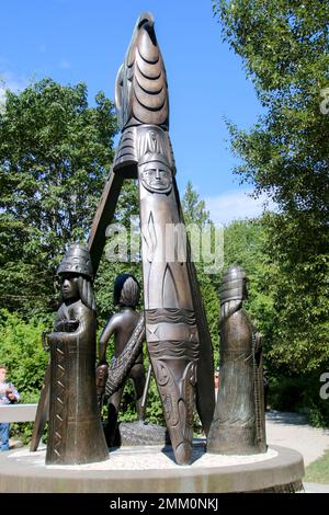 A totem pole depicting a salmon and two people adorns the tribal