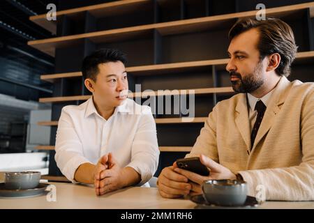 Multi ethnic business partners discuss project in laptop at office Stock Photo