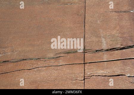 Abstract background of brown red wooden half log surface painted with wood furniture stain with cracks and knots to use for table or chair. Stock Photo