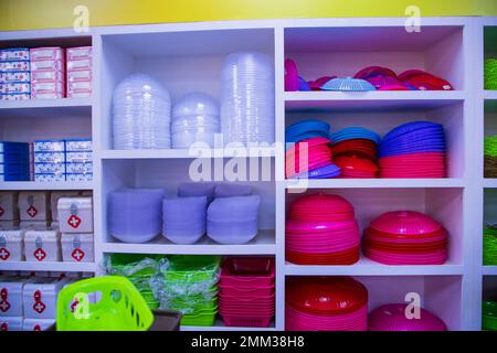 Colorful plastic tableware on shelves in the super shop. Close-up. Stock Photo
