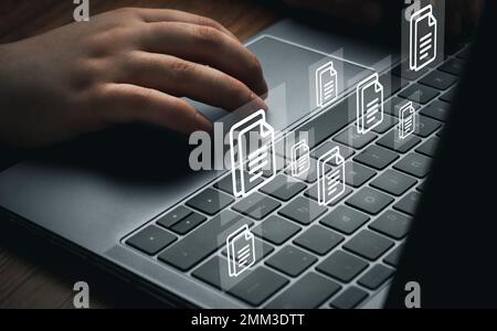 Woman using laptop with VR interface of documents. Document Management System (DMS) concept. Process automation to efficiently manage files. Stock Photo