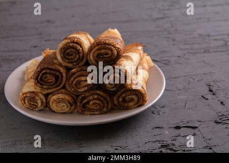 photo of fried pancakes lying on a plate against a dark background Stock Photo
