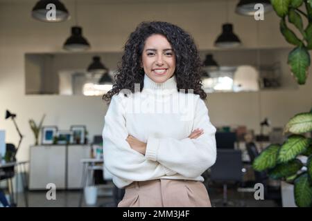 Young smiling latin business woman manager standing in office, portrait. Stock Photo