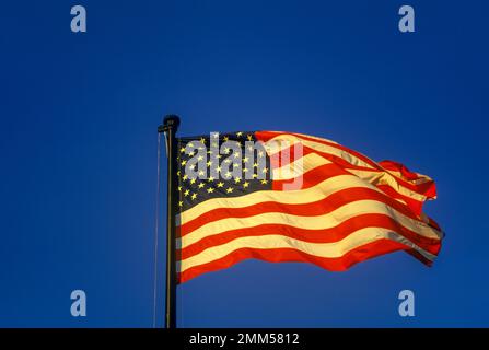 RIPPLING UNITED STATES FLAG FLYING ON FLAGPOLE Stock Photo