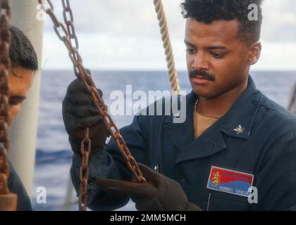 PHILIPPINE SEA (Sep. 14, 2022) Sonar Technician (Surface) 3rd Class Gabriel Garcia, from New York, assists lowering a torpedo on the aft missile deck aboard Arleigh Burke-class guided-missile destroyer USS Benfold (DDG 65), Sep. 14. Benfold is assigned to Commander, Task Force (CTF) 71/Destroyer Squadron (DESRON) 15, the Navy’s largest forward-deployed DESRON and the U.S. 7th Fleet’s principal surface force. Stock Photo