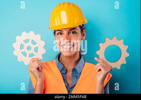 Woman with helmet join pieces of gears as concept of partnership and integration Stock Photo