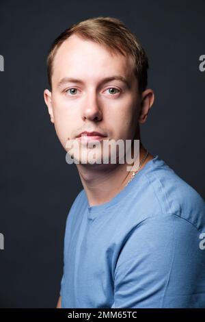 Portrait of young confident blond man in studio Stock Photo