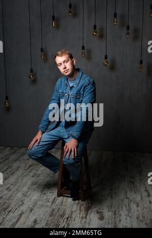 Portrait of young confident blond man in studio Stock Photo