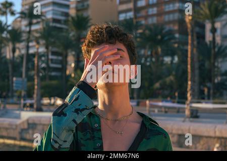 Stylish alternative young man put his hand on the face Stock Photo