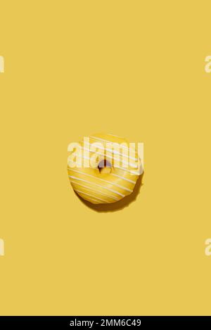 lemon doughnut in yellow glaze on a yellow background. pattern. Stock Photo