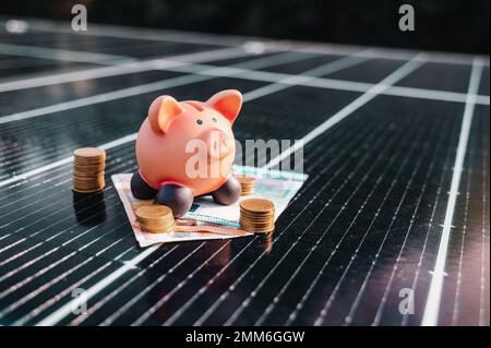 Money saved by using energy with solar panel on the roof Stock Photo