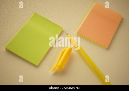 Yellow ballpoint pen and notes on beige paper. Stock Photo