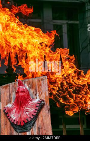 The symbol of a medieval executioner on a background of puffs of orange ...