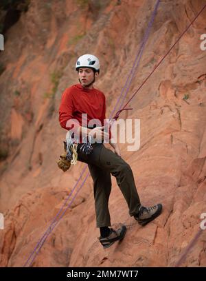 Josh Scott, a 4th Infantry Division veteran and a Outdoor Recreation Assistant for Fort Carson Morale, Welfare, and Recreation, demonstrates how to rock climb by showing the usage of the rope while harnessed on Sept. 15, 2022, Colorado Springs, Colorado. MWR is an Army wide program, and has plentiful outdoor trips in Colorado, spanning across all seasons. Stock Photo