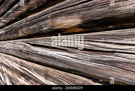Old wooden logs with natural patterns as background, wooden logs texture. Wall of round wooden logs Stock Photo