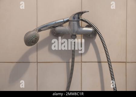 shower faucet with a watering head on a long hose in the bathroom, shower cabin with a faucet Stock Photo