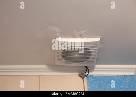 electric hood on the ceiling in the bathroom in the apartment, ventilation hole in the bathroom on the ceiling Stock Photo