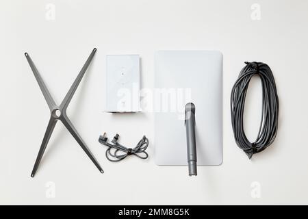 KYIV, UKRAINE - JANUARY 24, 2023: Starlink antenna, wi-fi router, base and cables, standard kit, top view on white background. Stock Photo