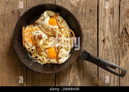 fried scrambled eggs with mushrooms in a pan on the table in the kitchen, fried egg Stock Photo