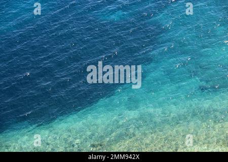 Azure water texture, transparent sea surface with a rocky bottom. Aerial view, natural turquoise background Stock Photo