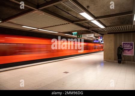Blurred motion of orange train leaving Rautatientori metro station in Helsinki, Finland Stock Photo