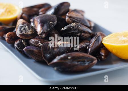 Close up of a plate with freshly coocked mussels on dining table Stock Photo