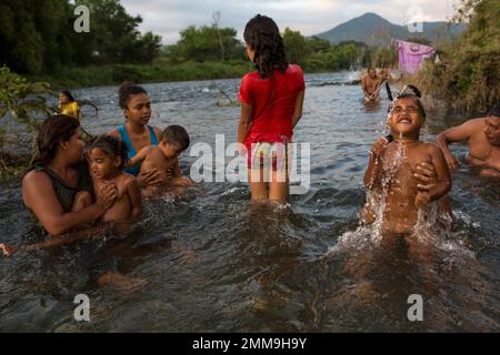 Honduran migrants have a bath in a river in Pijijiapan, Mexico