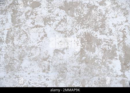 Old, gray concrete wall with peeling white paint Stock Photo