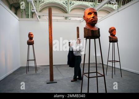 A man takes pictures with his phone of installations by artist Kader Attia displayed during the FIAC art fair at the Grand Palais in Paris, France, Thursday Oct. 18, 2018. (AP Photo/Francois Mori)