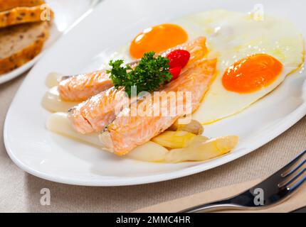 Fried salmon with scrambled eggs and asparagus Stock Photo