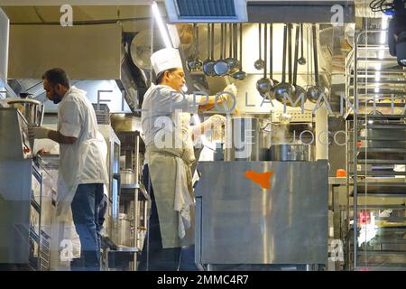 Group of chefs working in a modern kitchen of the restaurant. Milan, Italy - January 2023 Stock Photo
