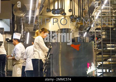 Group of chefs working in a modern kitchen of the restaurant. Milan, Italy - January 2023 Stock Photo