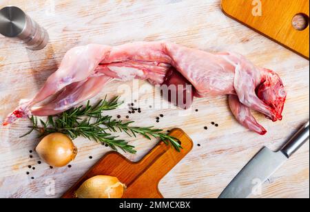 Raw skinless rabbit on wooden table Stock Photo