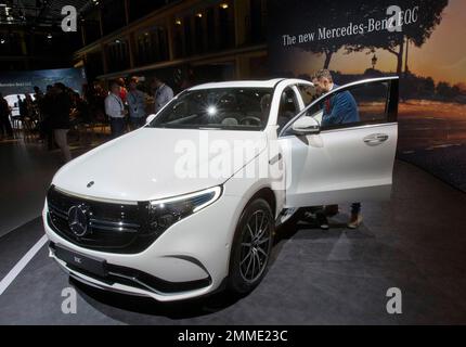 A man looks at a Mercedes-Benz EQC, electric luxury SUV during a media presentation on the eve of Paris Auto Show in Paris, France, Monday, Oct. 1, 2018. Doubts about diesel, Brexit, trade worries, tighter emissions controls. Those are the challenges that will be on the minds of auto executives when they gather this week ahead of the Paris Motor Show at the Porte de Versailles exhibition center. (AP Photo/Michel Euler)