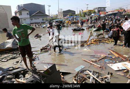 People survey the damage following earthquakes and a tsunami in Palu ...